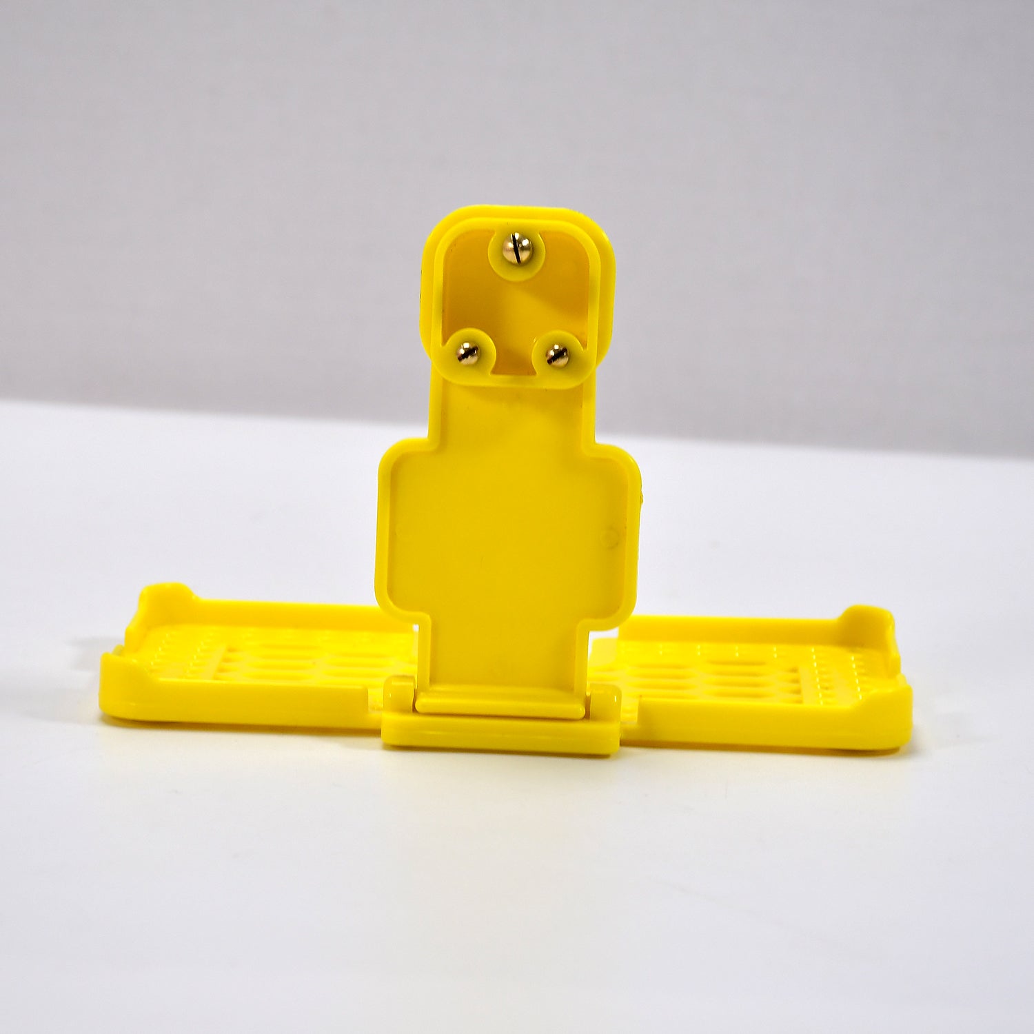 Yellow mobile holder for wall socket.